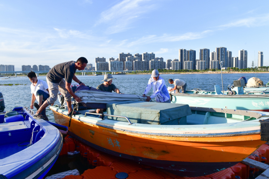 船員們通力協(xié)作，固定漁船。夏海濱攝