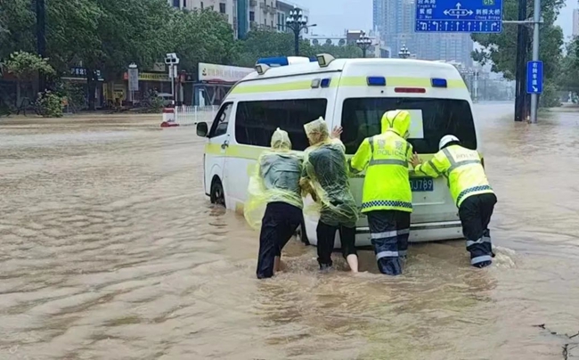 晉江交警合力將拋錨的救護(hù)車推離積水路段。泉州公安供圖